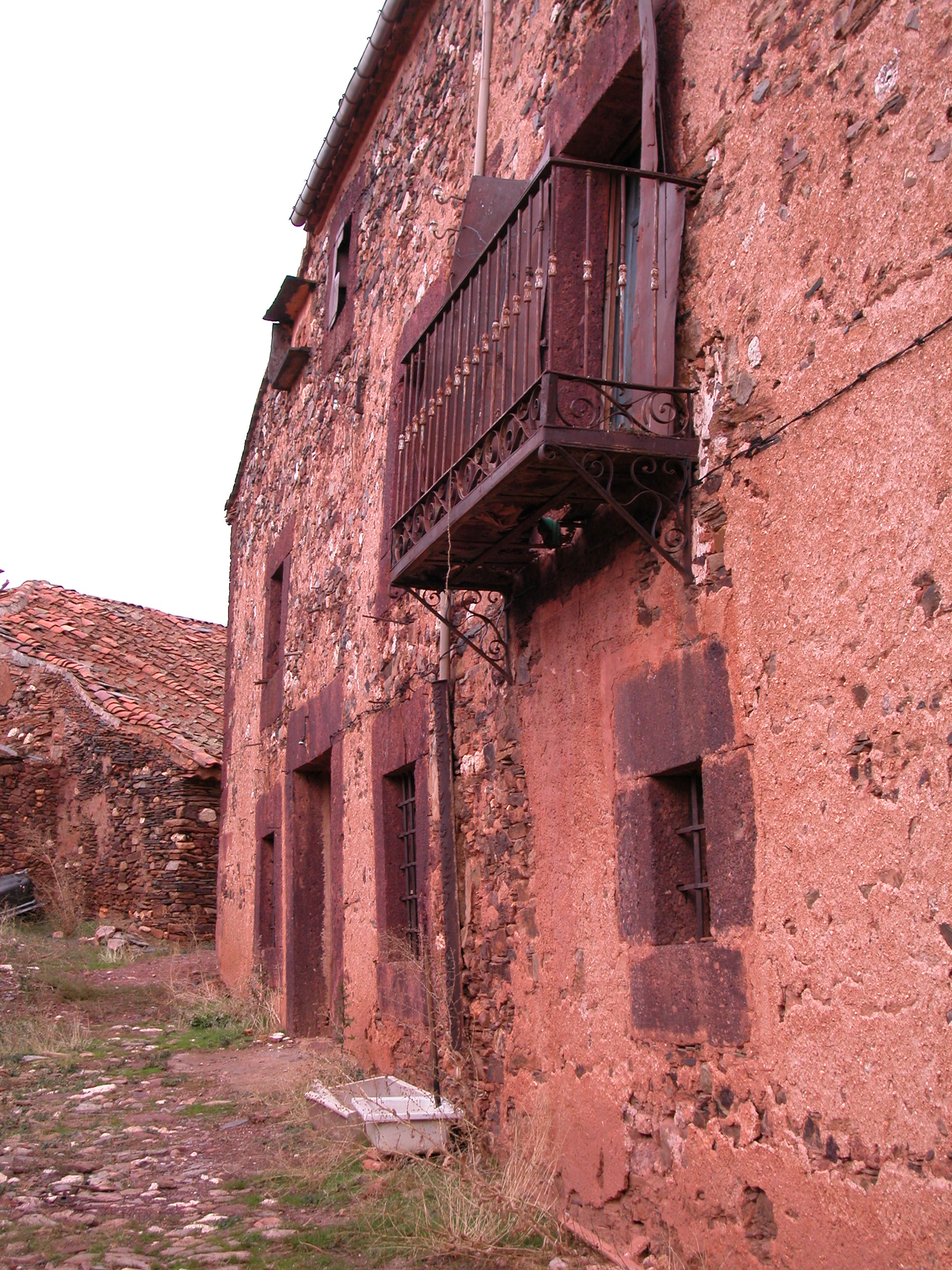 Fig 11. Fachada de mampostería revocada y conglomerado rojizo del Terciario en recercados de vanos. Madriguera. 