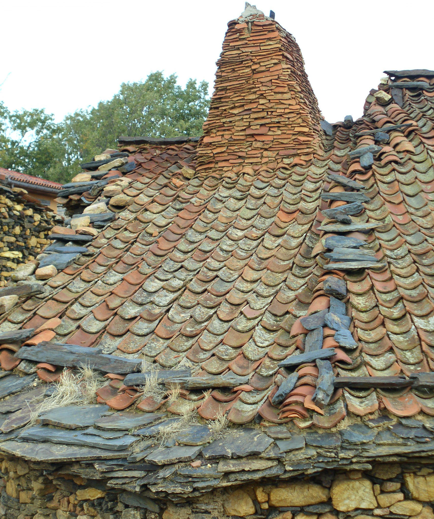 Fig 4. Chimenea de piezas cerámicas, colocación de tejas "a la segoviana" y lajas de pizarra encajadas en 1ª línea de cubierta. Martín Muñoz de Ayllón.